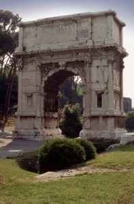 The Arch of Titus from outside the Forum, Rome, Italy.  Located at the highest point of the Via Sacra which leads to the Roman Forum, this triumphal arch, with only one passageway, commemorates Titus' conquest of Judea which ended the Jewish Wars (66-70). Engaged fluted columns frame the passageway.